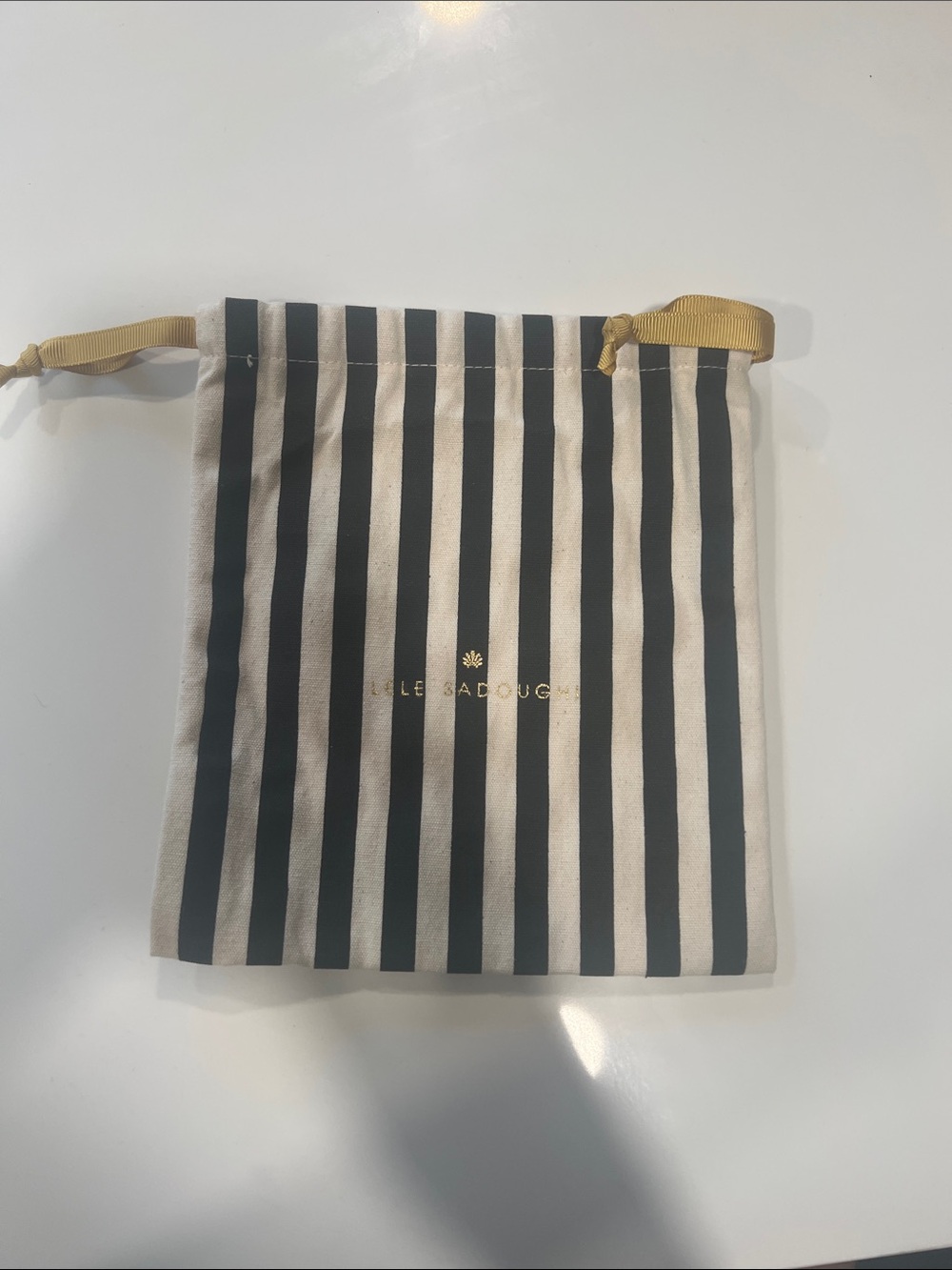 Lele Sadoughi Black and Cream Striped Drawstring Pouch with Gold Ribbon Detail